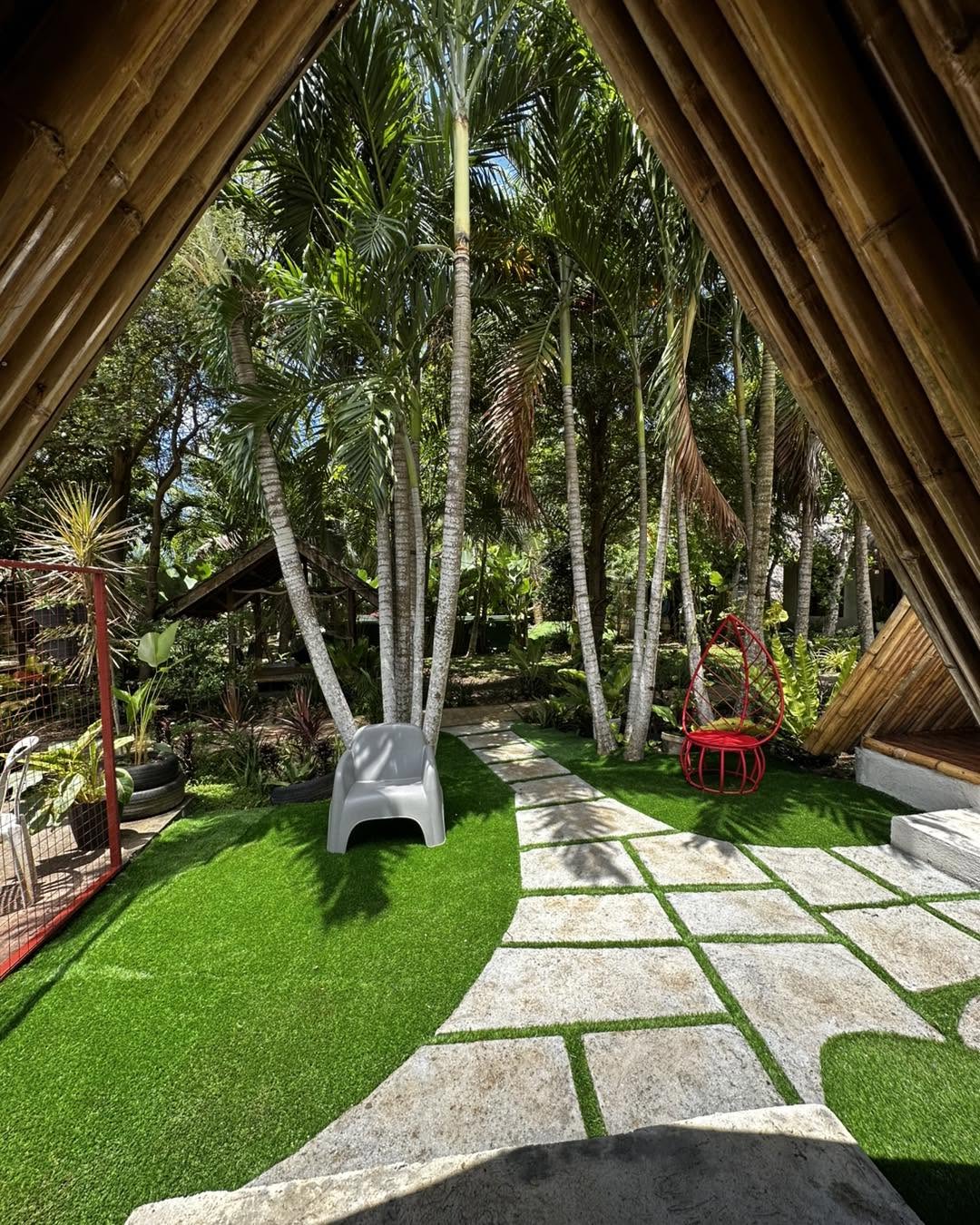 Garden path framed by the bamboo roofline of a guest cottage