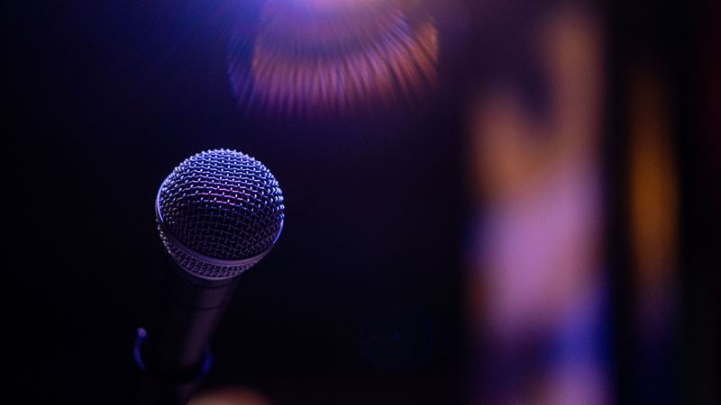 A microphone lit in purple stage light