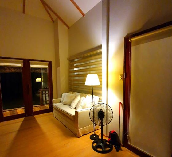 Warm lamplight on the Kubo's couch and glass doors in the evening