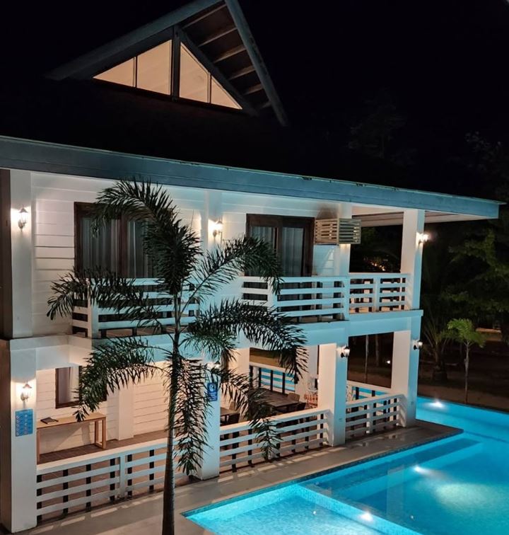 Lit verandas of the main building above the glowing pool