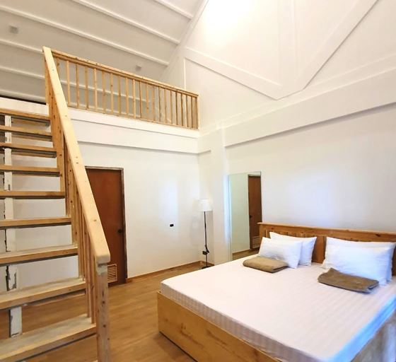 A large timber bed below a staircase to the loft