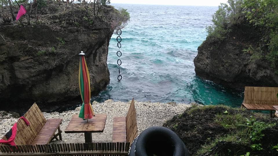 A rocky cove with a rope swing and bamboo benches near Padre Burgos
