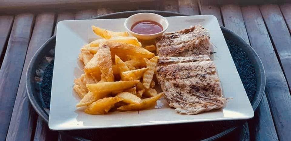 A plate of grilled fish and fries served at JD Beach Front Hotel