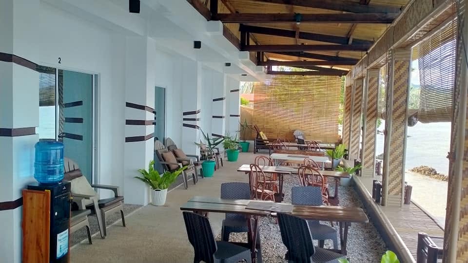 Covered waterfront dining and seating area at JD Beach Front Hotel