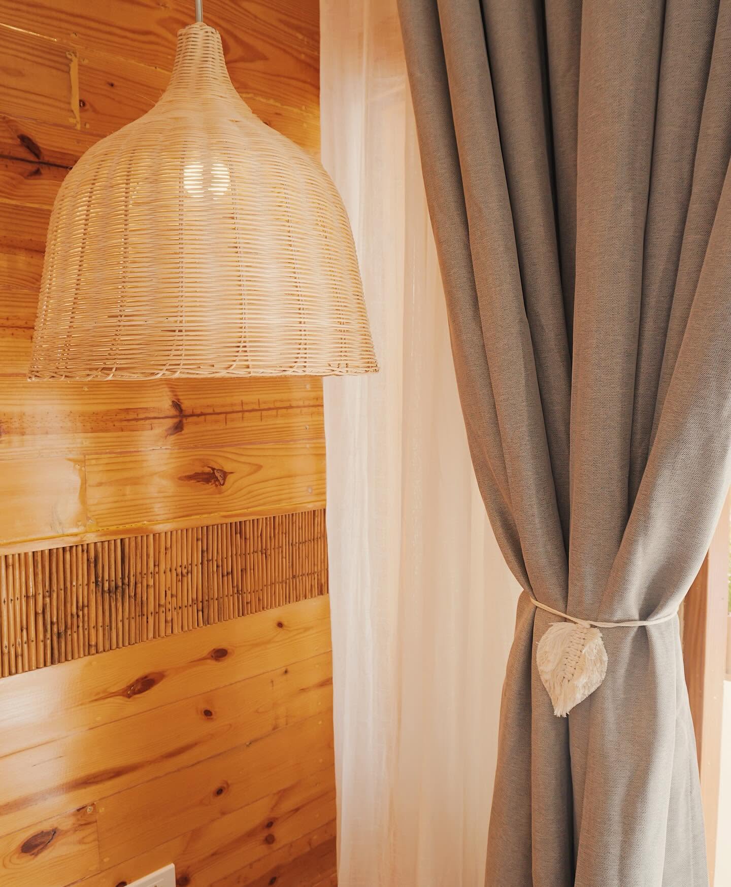 Rattan pendant light and linen curtain detail