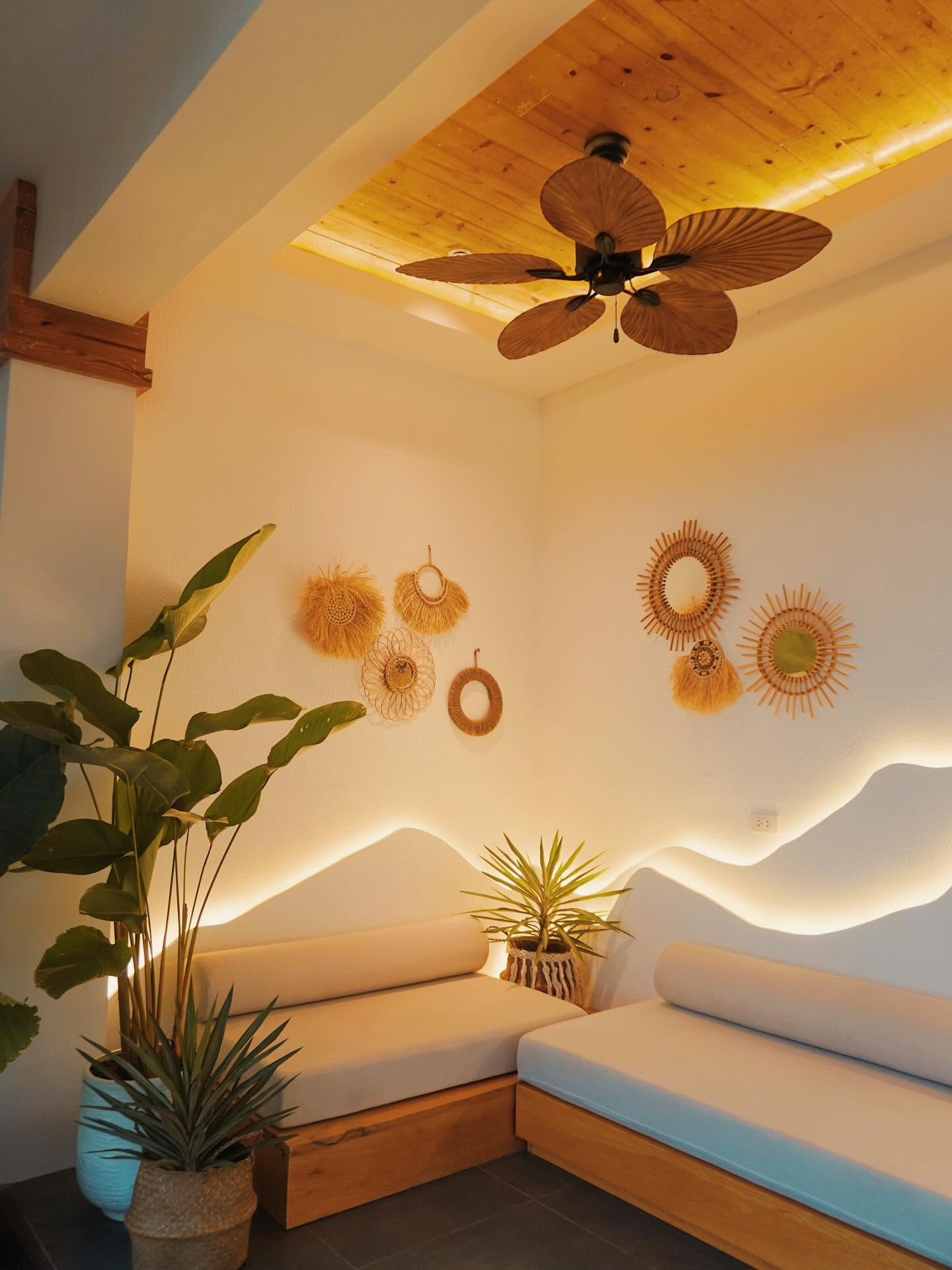 Woven wall art and a palm-leaf ceiling fan in a lounge nook