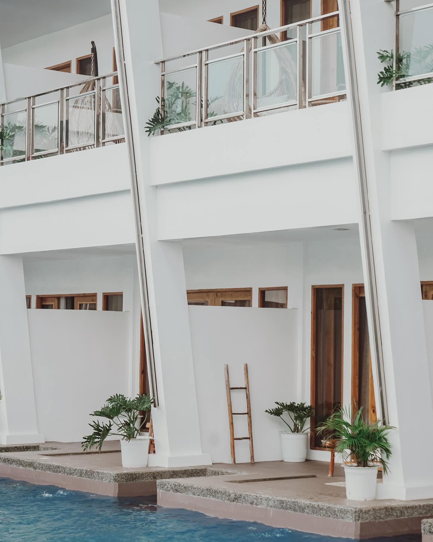 White columns and potted plants along the pool