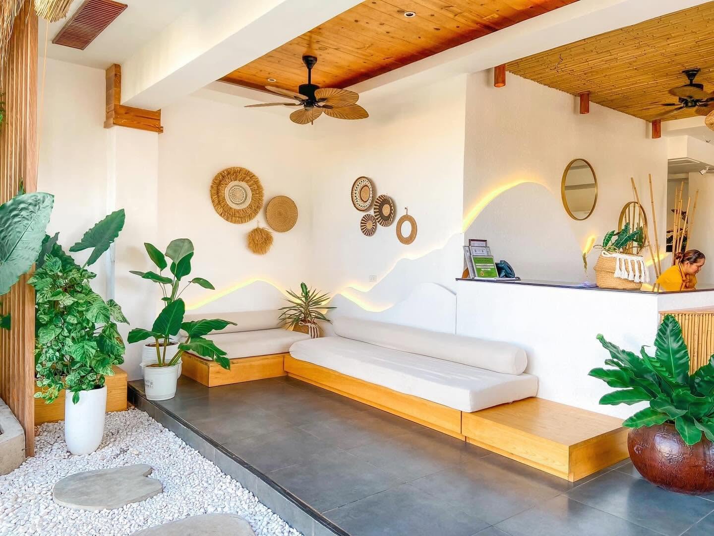 Molly Resort Bohol lobby with woven wall art, plants and low daybed seating