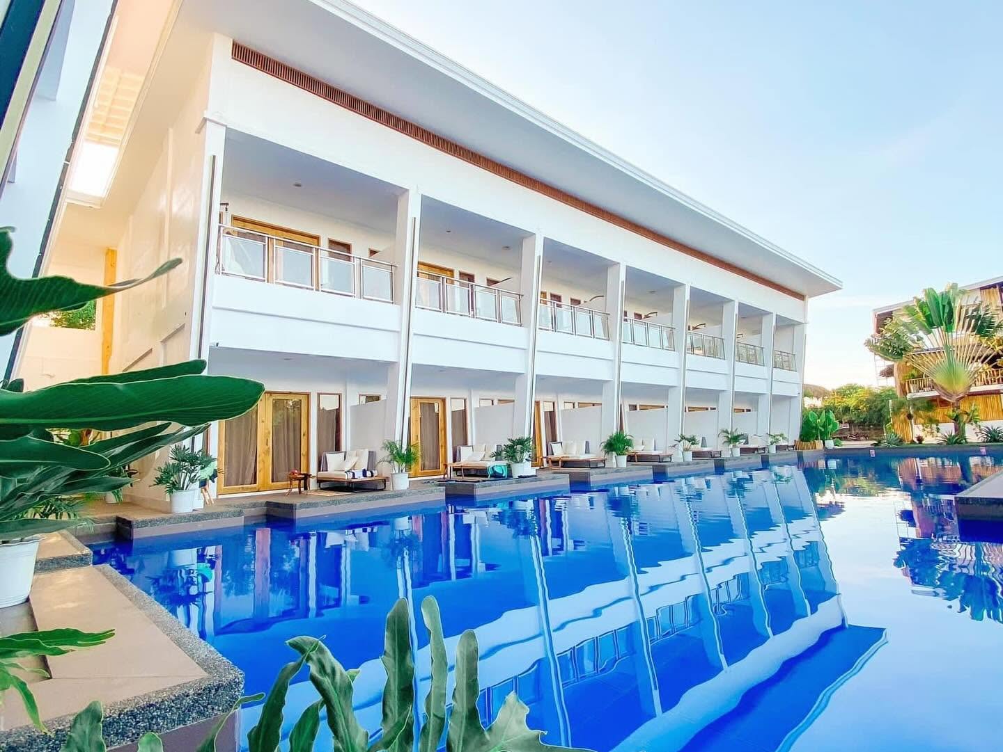 Resort facade reflected in the pool at dusk