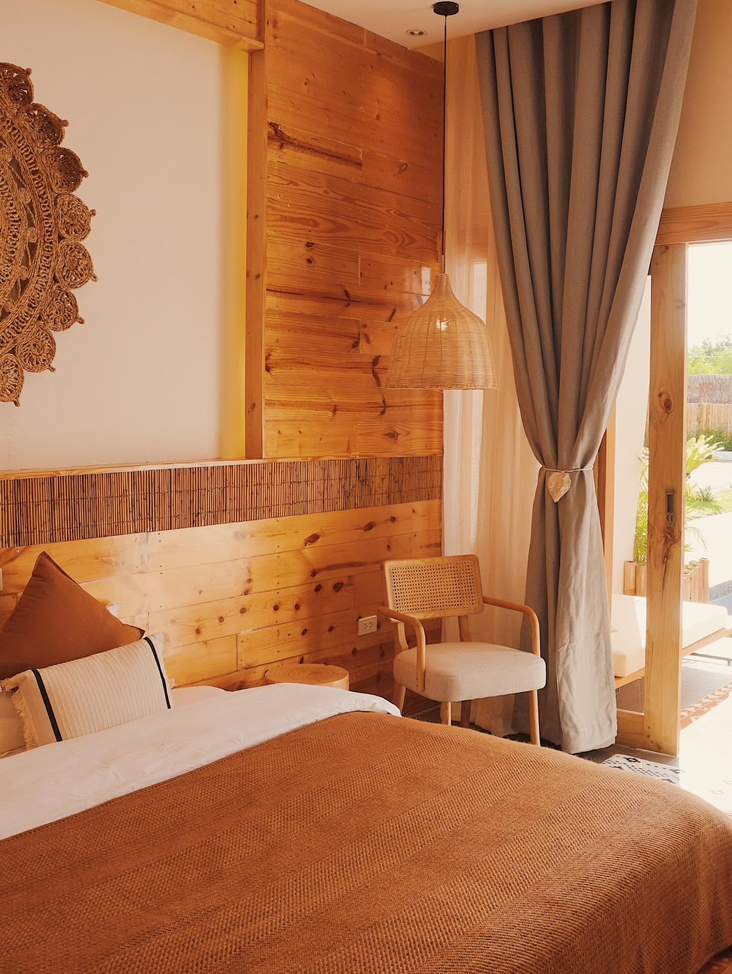 Bed, cane chair and balcony doors in warm light