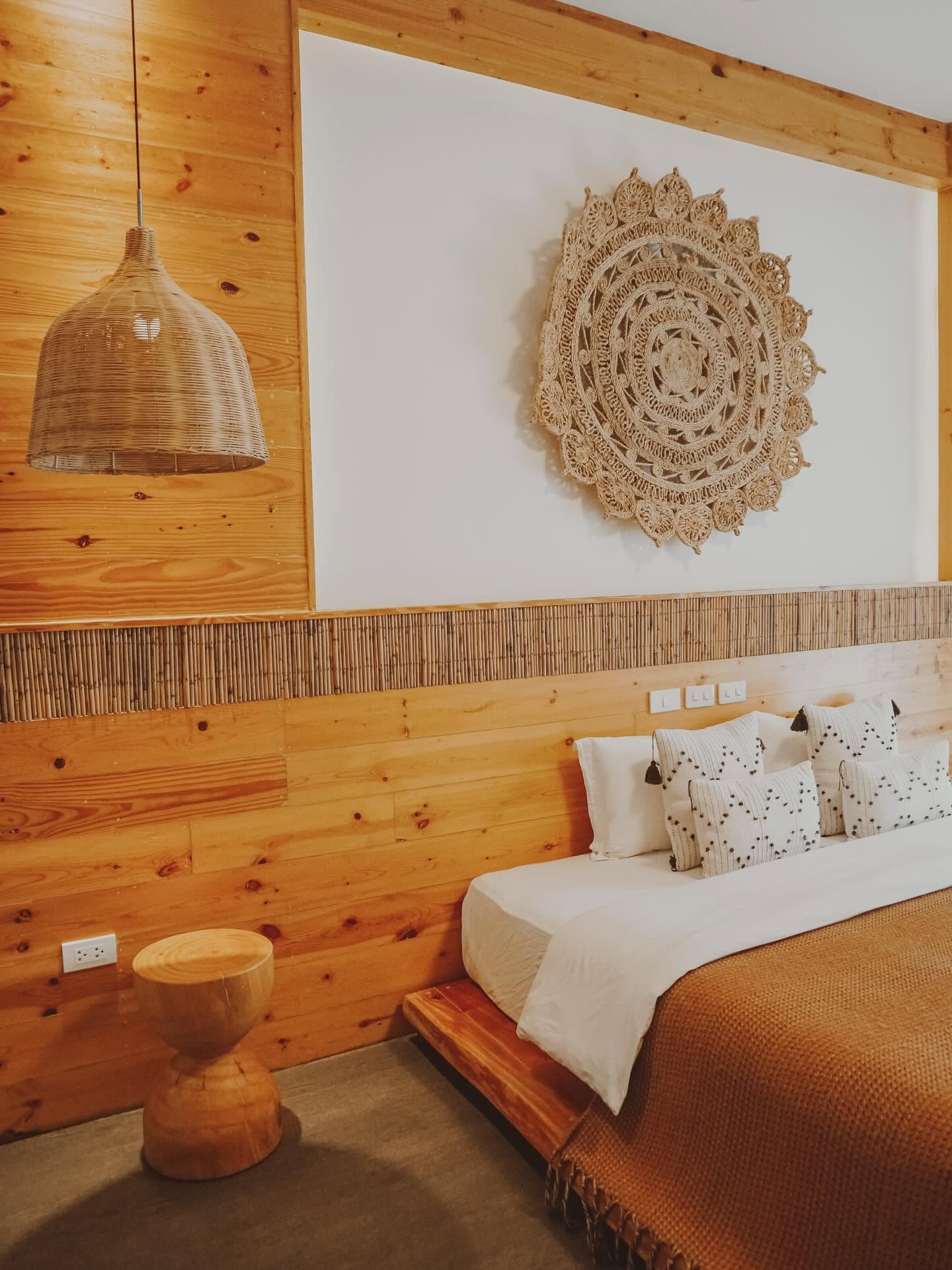 King bed with a large woven mandala on the wall above