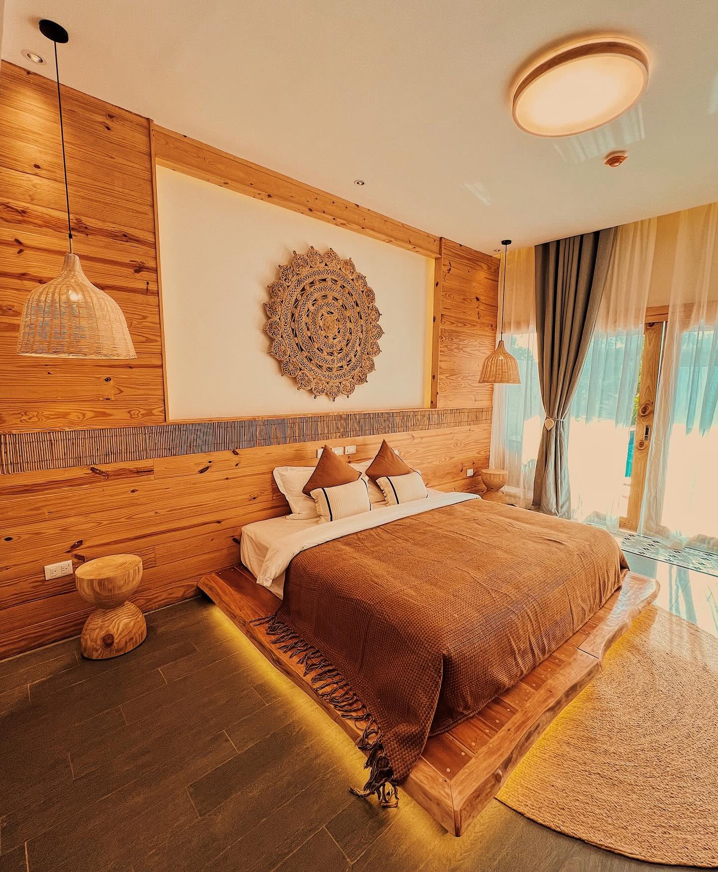 Deluxe King Room with a low platform bed, layered textiles and a large woven wall piece