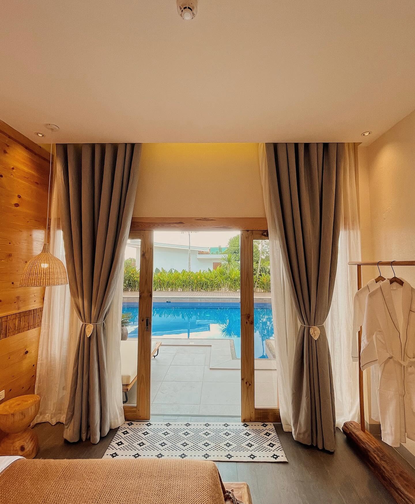 Poolside Deluxe Room with sheer curtains opening onto the pool terrace