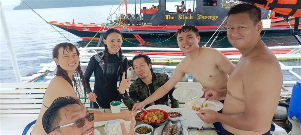 Guests sharing a meal onboard during a multi-day dive trip