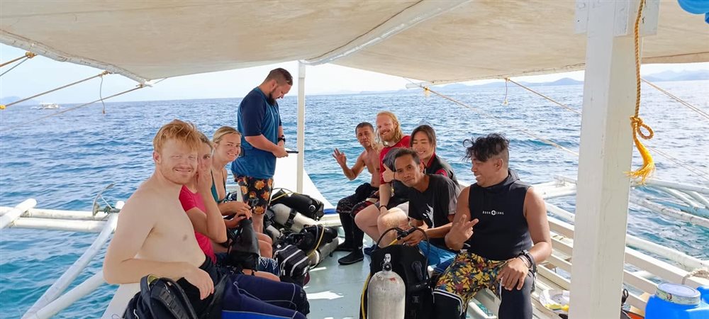 A group of guests on the dive boat at sunset