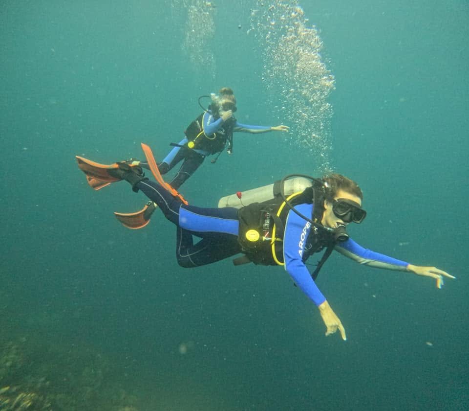 Two divers descending together on a Coron dive site