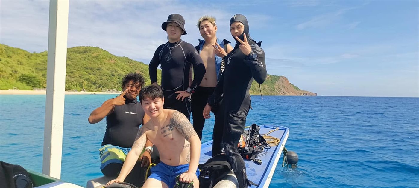 Guests aboard a dive boat with Coron's islands in the background